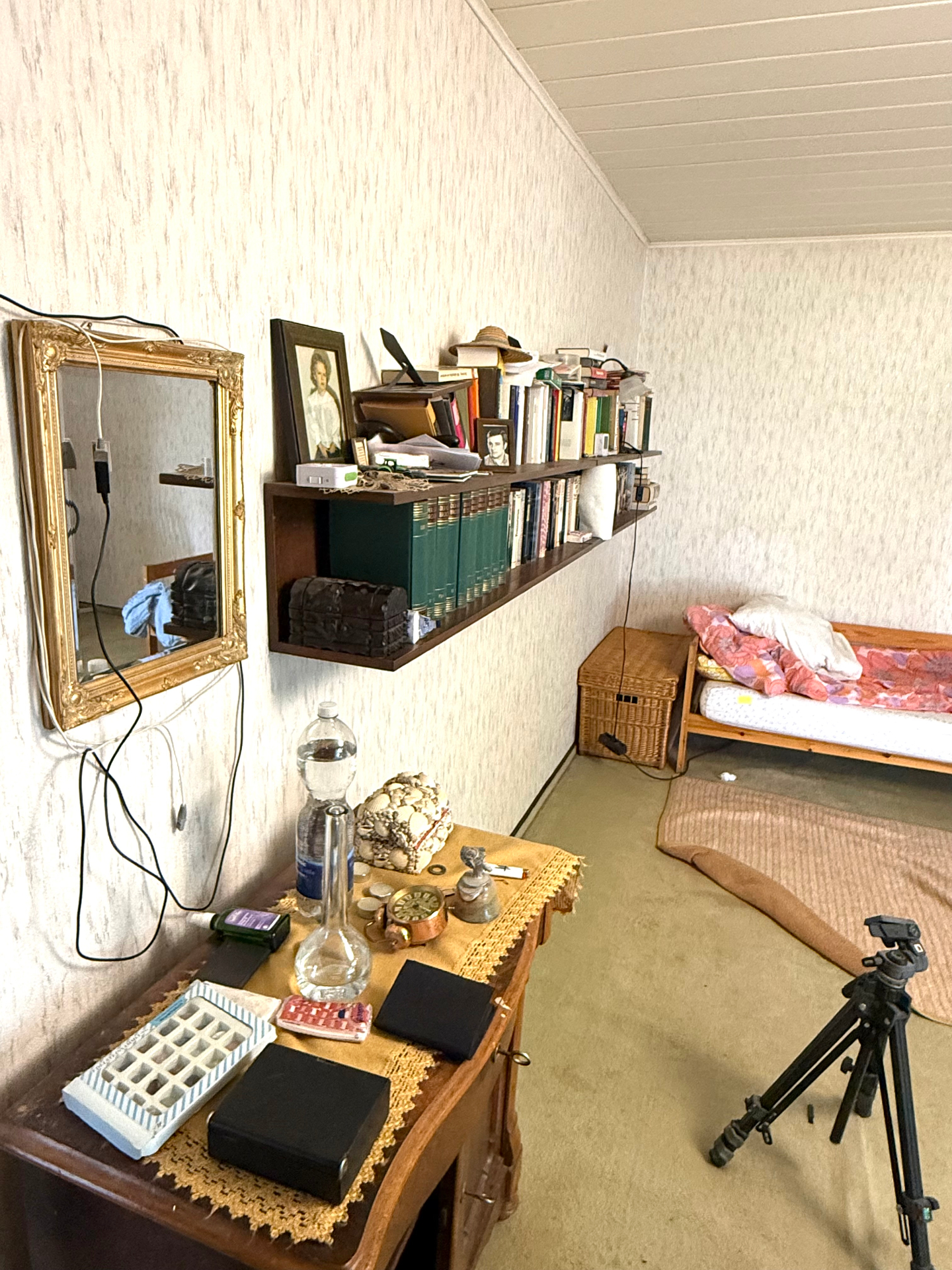 Vorher: voll möbliertes Schlafzimmer mit Bett, Kommode, Spiegel und Bücherregal